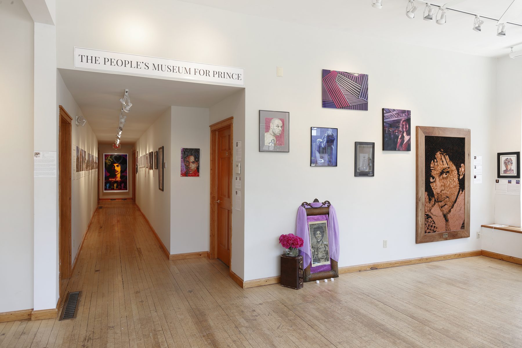 The People's Museum for Prince at Roberts Gallery: artworks on white walls either side of a corridor